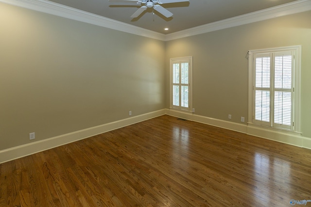 empty room with visible vents, ornamental molding, dark wood-type flooring, ceiling fan, and baseboards