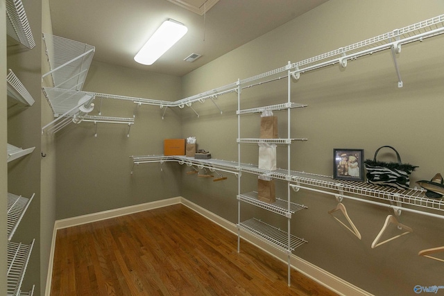 spacious closet featuring attic access, visible vents, and wood finished floors