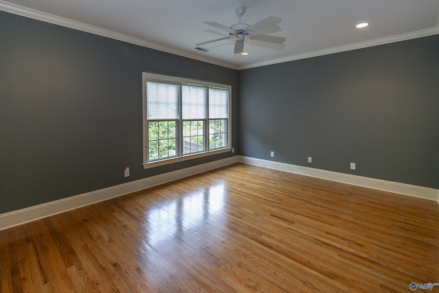 unfurnished room featuring ornamental molding, wood finished floors, visible vents, and baseboards