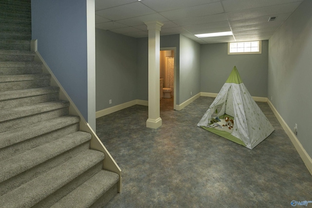 below grade area with carpet floors, a paneled ceiling, visible vents, stairway, and baseboards