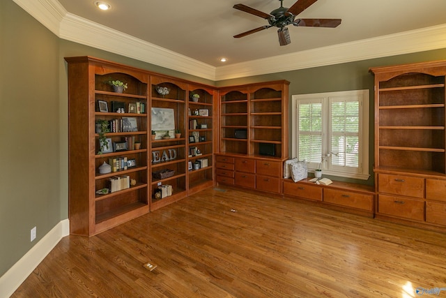 interior space with baseboards, crown molding, a ceiling fan, and wood finished floors