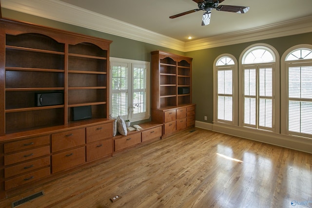 unfurnished office featuring light wood-style floors, a ceiling fan, visible vents, and crown molding