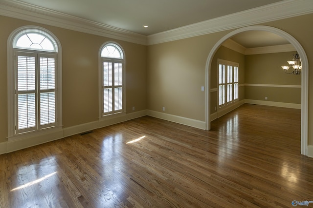 spare room featuring wood finished floors, visible vents, and baseboards