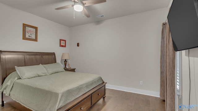 bedroom with baseboards, visible vents, wood finished floors, and ceiling fan