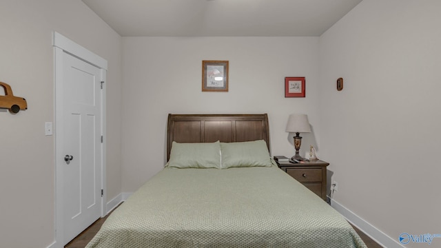 bedroom featuring baseboards and dark wood-style flooring