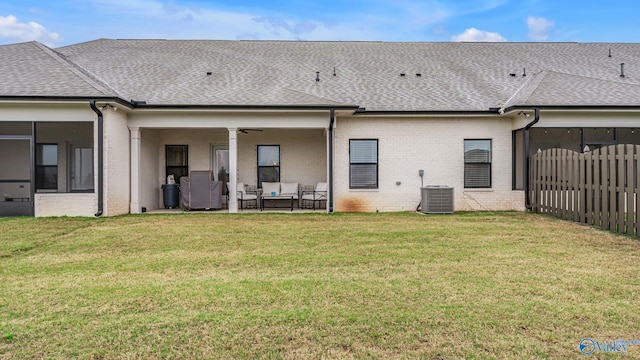 rear view of property featuring fence, outdoor lounge area, a shingled roof, and brick siding