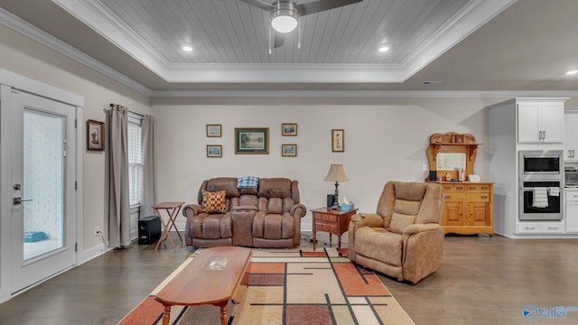 living area featuring wood finished floors, ornamental molding, and a raised ceiling