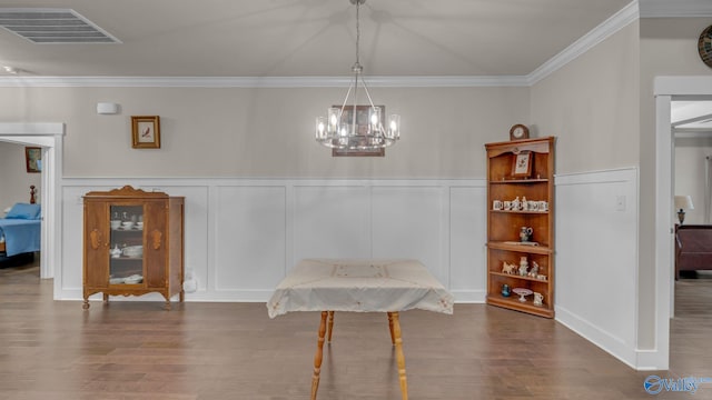 dining room featuring ornamental molding, an inviting chandelier, visible vents, and wood finished floors