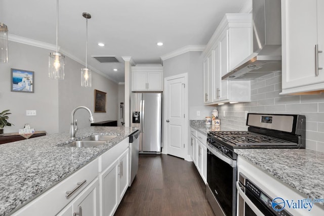 kitchen featuring wall chimney range hood, sink, appliances with stainless steel finishes, tasteful backsplash, and white cabinetry