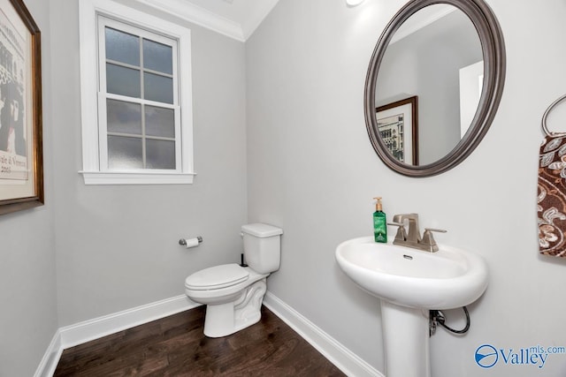 bathroom featuring toilet, wood-type flooring, and crown molding