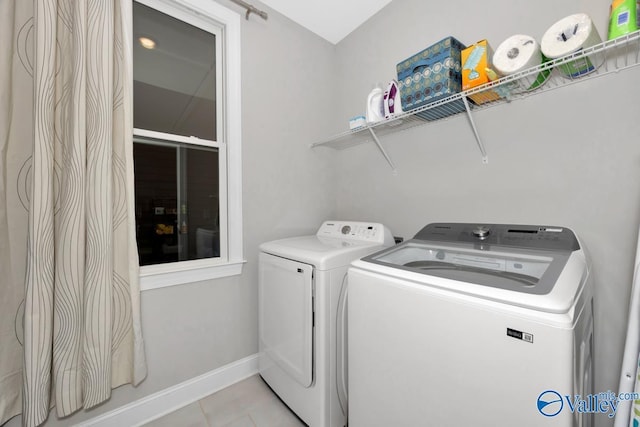 washroom featuring light tile patterned flooring and washing machine and clothes dryer