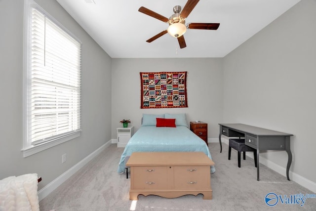 carpeted bedroom featuring multiple windows and ceiling fan