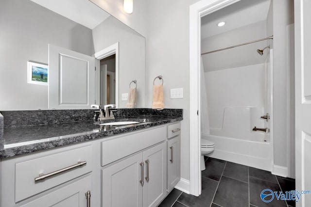 full bathroom featuring toilet, vanity, tile patterned floors, and washtub / shower combination