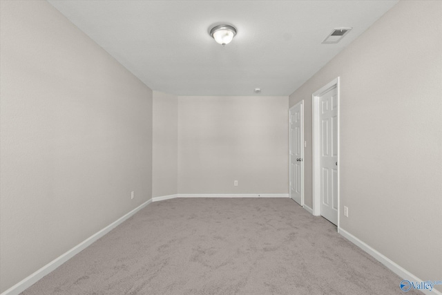 spare room featuring light carpet