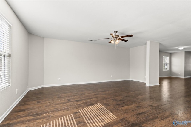 spare room with ceiling fan, a healthy amount of sunlight, and dark hardwood / wood-style flooring