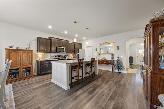 165 Saddle St, New Market, AL 35761 - kitchen featuring stainless steel microwave, arched walkways, freestanding refrigerator, dark wood-style flooring, and recessed lighting