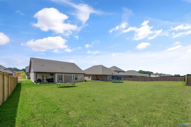 165 Saddle St, New Market, AL 35761 - back of house with a trampoline, a fenced backyard, and brick siding