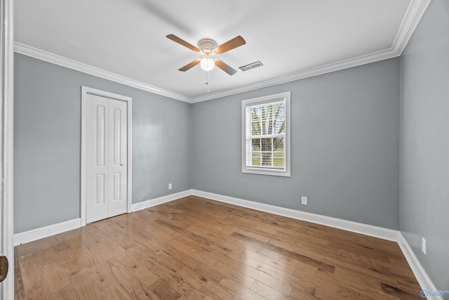 unfurnished room featuring hardwood / wood-style floors, ceiling fan, and crown molding