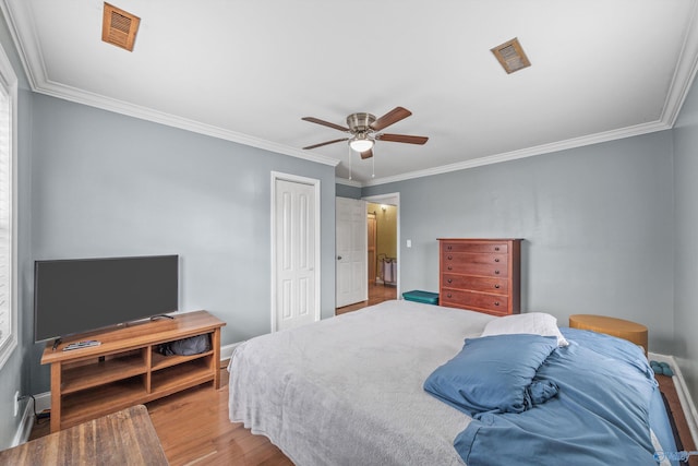 bedroom featuring hardwood / wood-style floors, ceiling fan, and crown molding