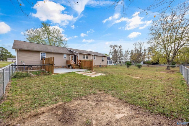 back of property with a wooden deck, a lawn, and a patio area