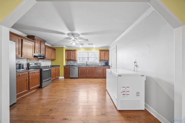 kitchen featuring stainless steel appliances, ceiling fan, light hardwood / wood-style flooring, and ornamental molding