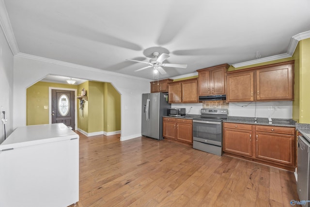 kitchen featuring light wood-type flooring, crown molding, and stainless steel appliances