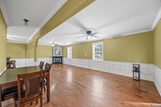 dining area featuring ceiling fan, wood-type flooring, and crown molding