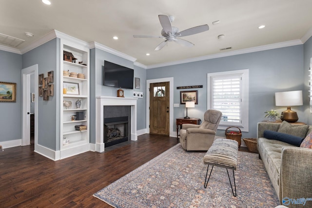 living room with ornamental molding, dark wood-type flooring, and ceiling fan