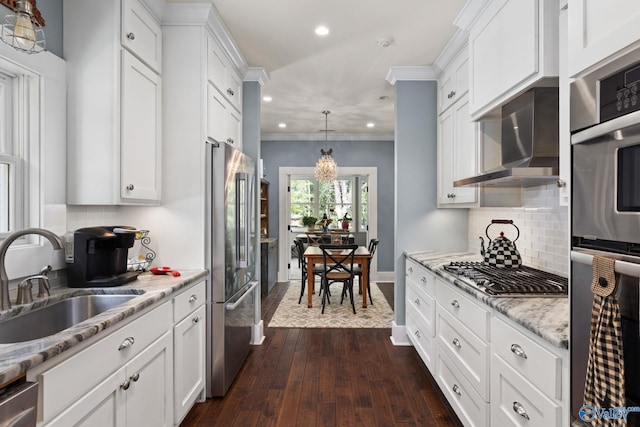 kitchen with sink, stainless steel appliances, white cabinets, ornamental molding, and dark hardwood / wood-style floors