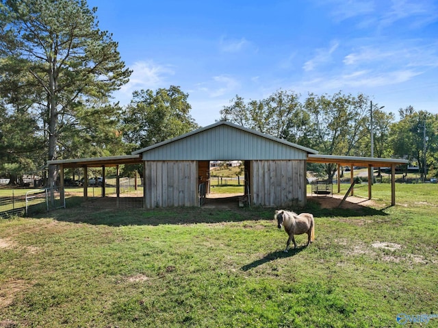 view of outbuilding with a lawn and a rural view