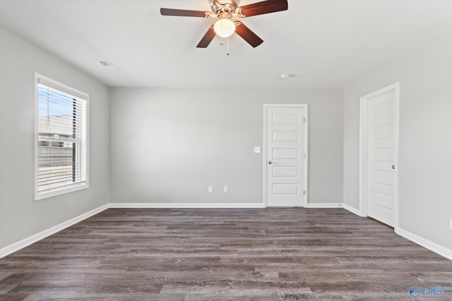 unfurnished room with dark wood finished floors, baseboards, and ceiling fan