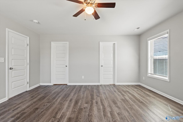 unfurnished bedroom featuring dark wood-type flooring, baseboards, and a ceiling fan