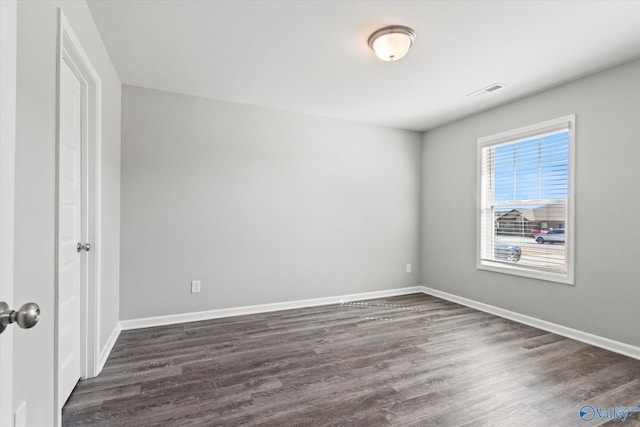 unfurnished bedroom featuring visible vents, baseboards, and dark wood-type flooring