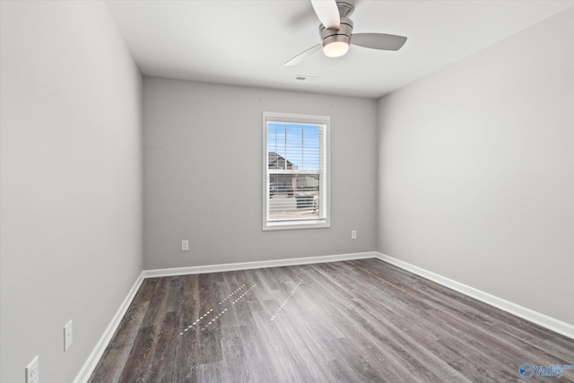 unfurnished room featuring ceiling fan, dark wood finished floors, visible vents, and baseboards