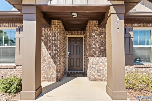 doorway to property with brick siding and board and batten siding