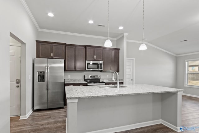 kitchen featuring stainless steel appliances, a sink, visible vents, an island with sink, and decorative light fixtures