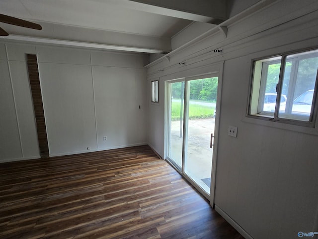 empty room with beam ceiling, dark wood-style floors, and ceiling fan