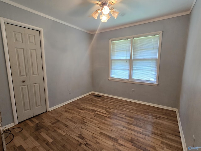unfurnished room with a ceiling fan, wood finished floors, baseboards, and ornamental molding