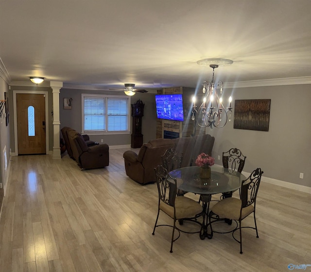 dining space featuring ornamental molding, decorative columns, and light wood-type flooring