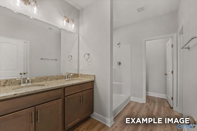 bathroom featuring a shower, hardwood / wood-style floors, and vanity