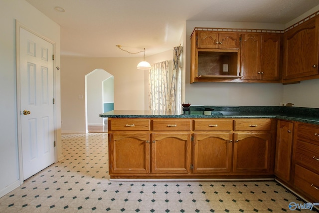 20886 Johnson Dr, Athens, AL 35613 - kitchen featuring a peninsula, light floors, brown cabinetry, and arched walkways