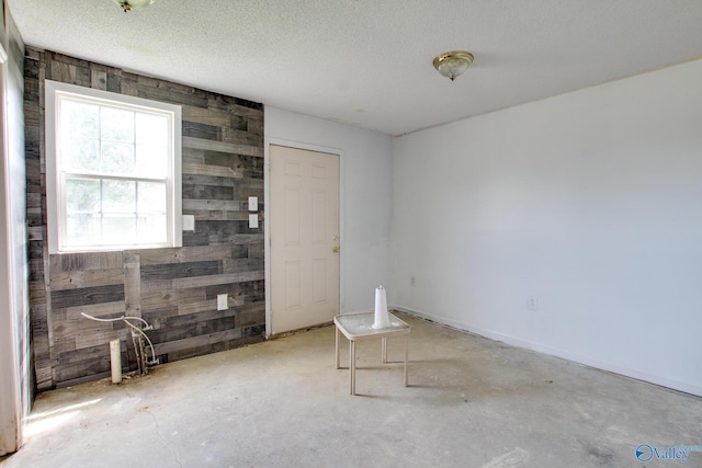 20886 Johnson Dr, Athens, AL 35613 - unfurnished room featuring a textured ceiling, wood walls, and unfinished concrete floors