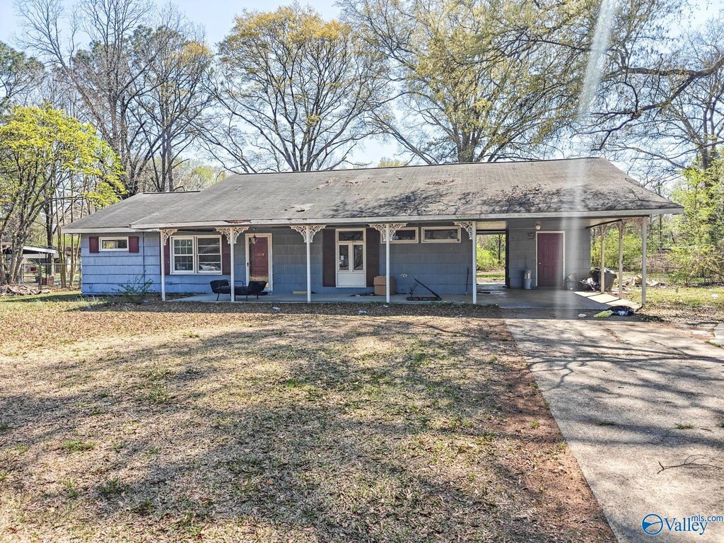 single story home with driveway, a carport, and a porch
