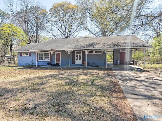 single story home with driveway, a carport, and a porch