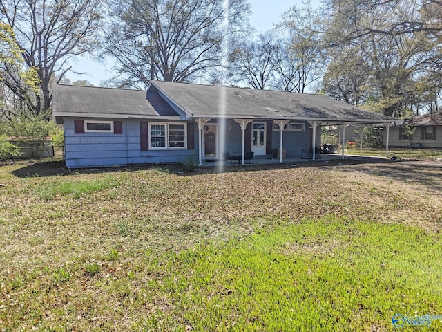 single story home featuring an attached carport, fence, and a front lawn