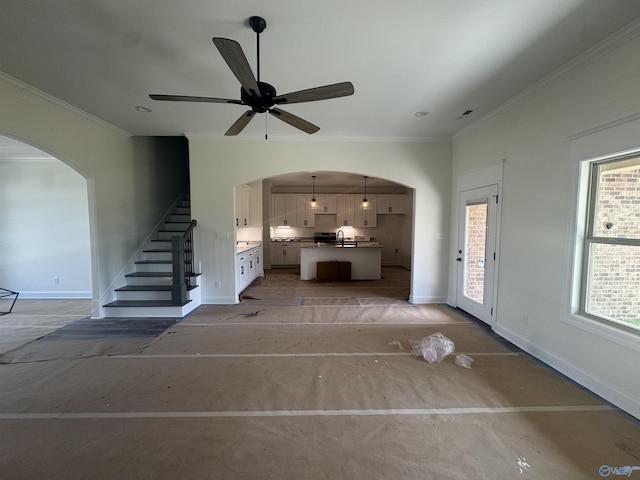 215 Dogwood Dr, Rogersville, AL 35652 - unfurnished living room with arched walkways, baseboards, stairway, ornamental molding, and a sink