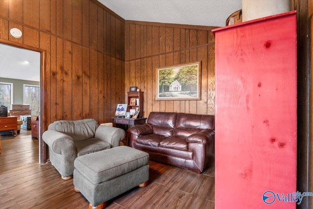 living room featuring lofted ceiling, dark hardwood / wood-style flooring, and wood walls