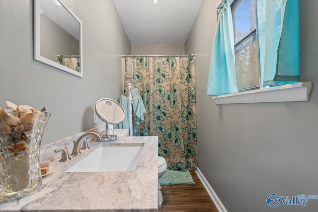 bathroom with vanity, toilet, hardwood / wood-style floors, and a textured ceiling