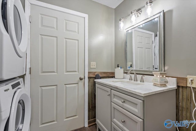 bathroom with vanity and stacked washer / drying machine