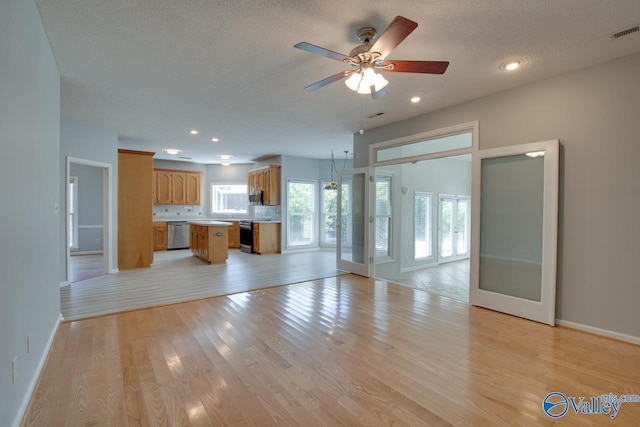 1102 Chesterfield Dr SE, Huntsville, AL 35803 - unfurnished living room with baseboards, ceiling fan, light wood-style flooring, a textured ceiling, and french doors